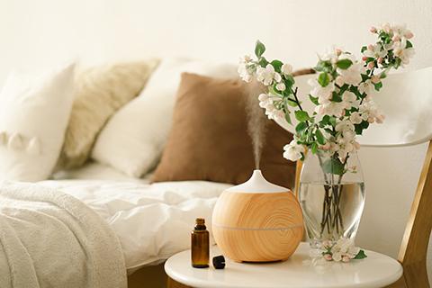 Aroma essential oils diffuser on chair against in the bedroom. Air freshener. Ultrasonic aroma diffuser for home. 
